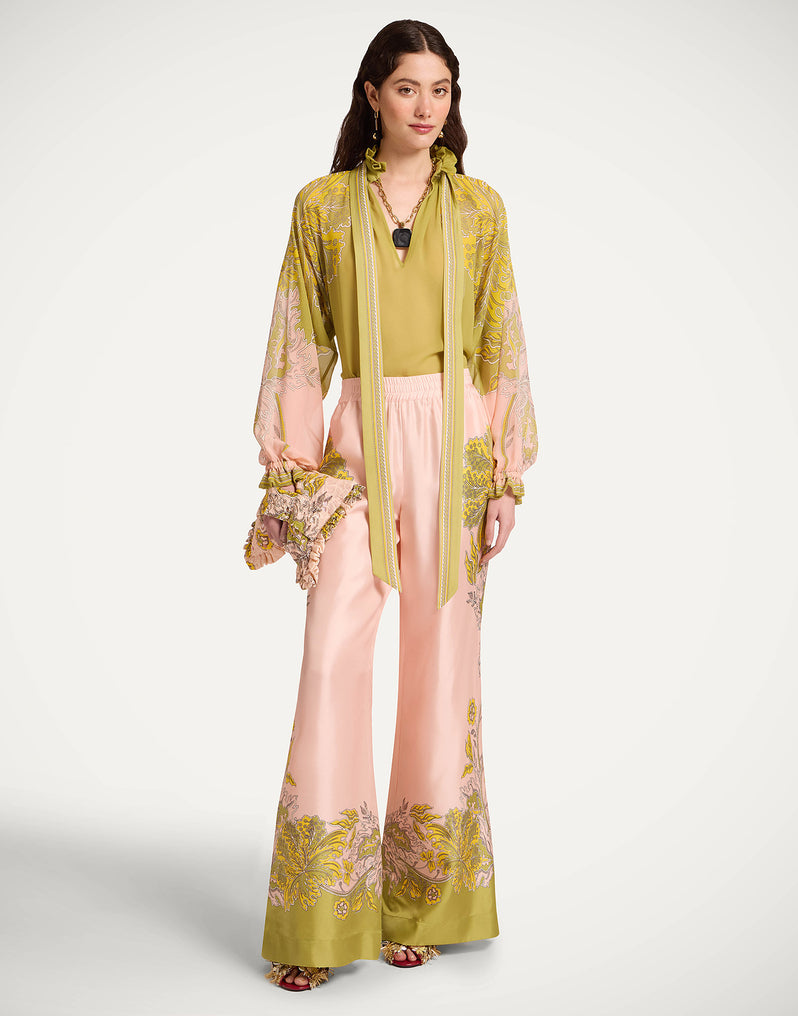 Woman wearing a floral outfit with a sheer yellow top and pink pants from La Double J. 